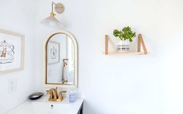 Person installing a floating shelf on a wall
