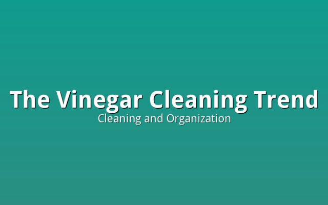 A bottle of white vinegar next to cleaning cloths representing the vinegar cleaning trend